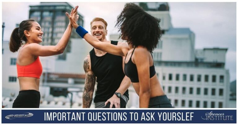three-personal-trainers-standing-in-a-circle-celebrating-with-a-high-five