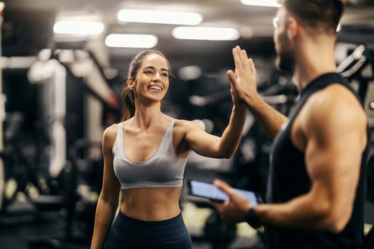 Fitness coach giving client a high five